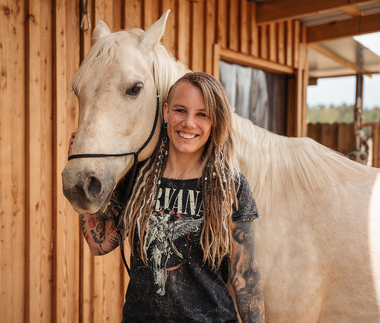 Frau mit Pferd vor Holzwand